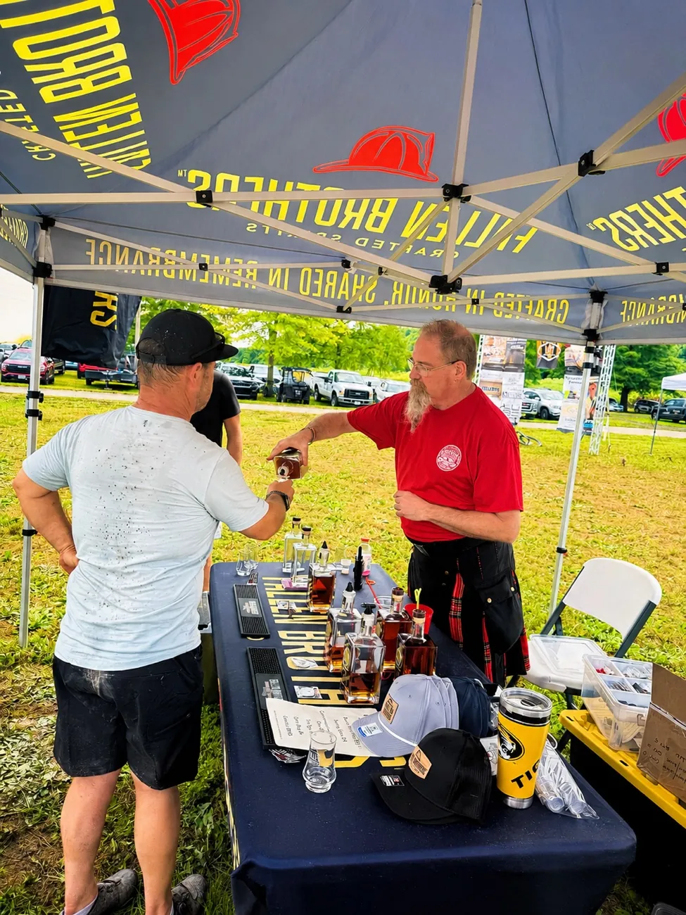 A vendor sharing a tasting under the Fallen Brothers tent at the 1st Annual MO Spirit Festival